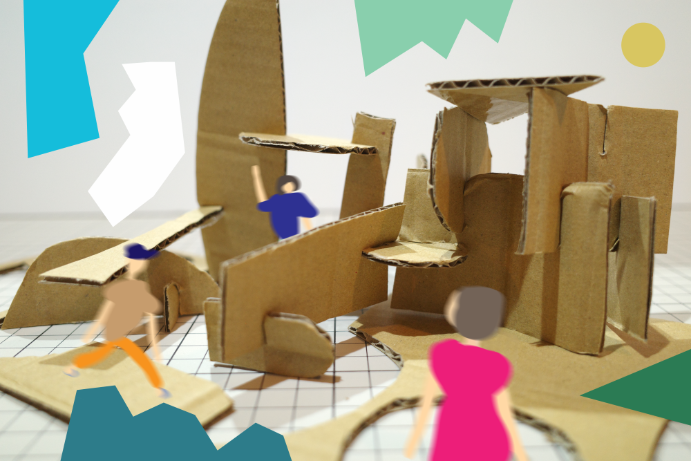 「砂浜にお城をつくろう」のアイキャッチ画像です。ダンボールで作られた小さな建物のような立体物が、方眼紙の上に組み立てられて置かれています。写真とデジタルイラストを組みわせたような画像で、周囲には、人物3人のイラストが描かれています。手前の人物は、強めのピンクのワンピース、左の人はベージュのトップスに橙色のパンツ、奥の人は紺色のトップスを着ています。背景にはカラフルでポップな図形がポイントとして入っています。